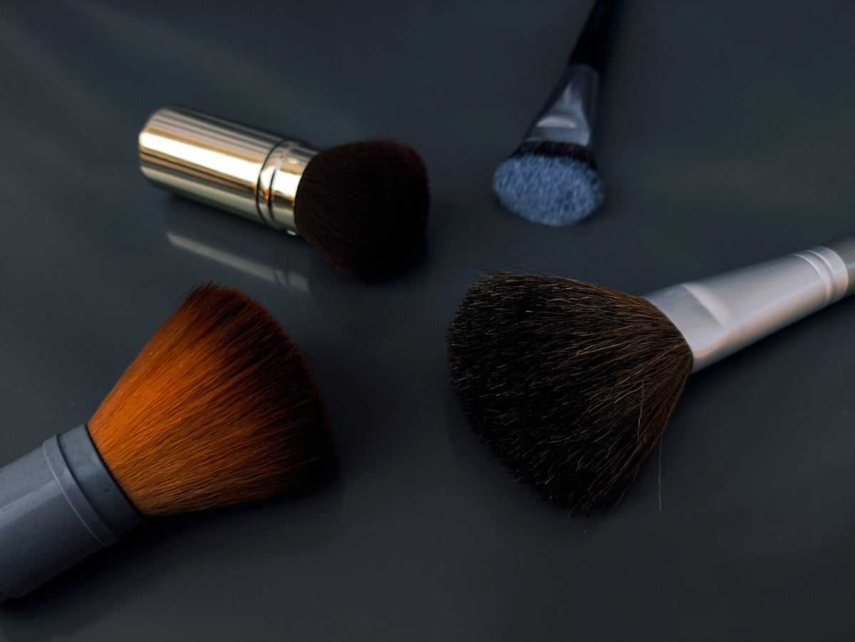 A close up of three makeup brushes on a table