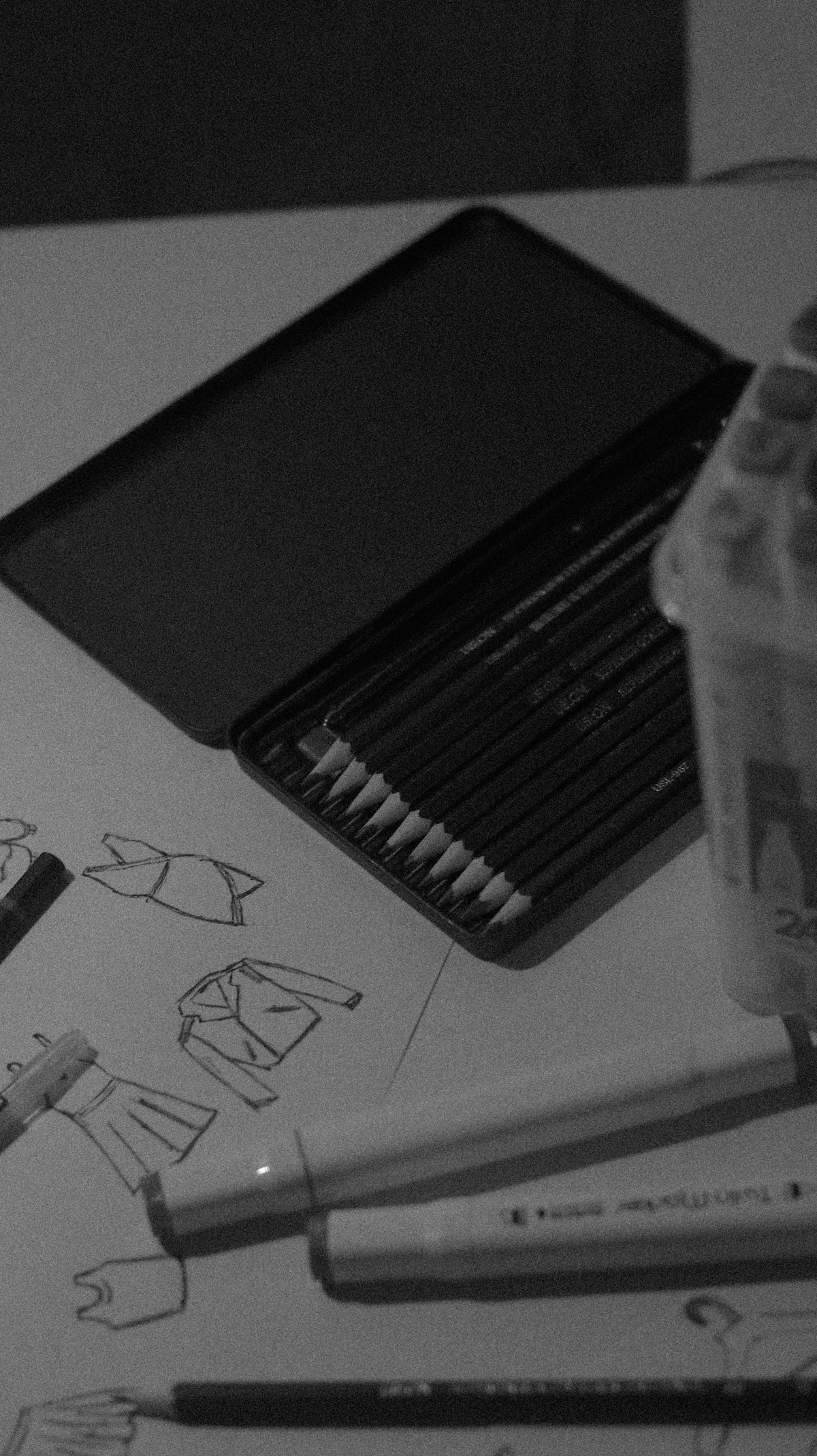 Pencils and fashion sketches on a table