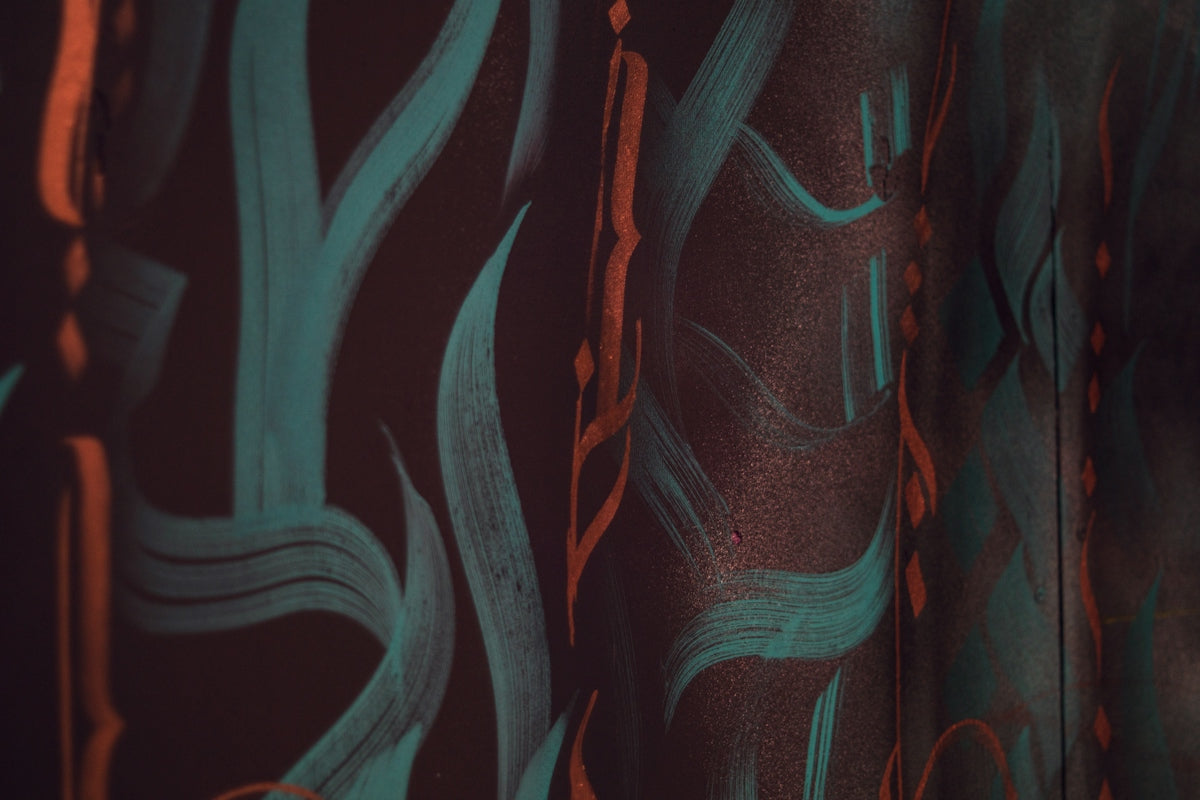 Abstract teal and orange brush strokes on dark background.