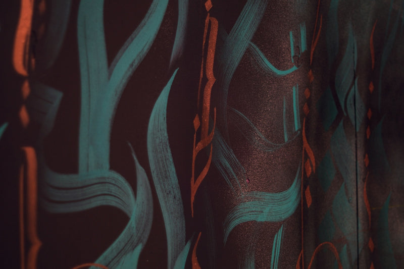 Abstract teal and orange brush strokes on dark background.