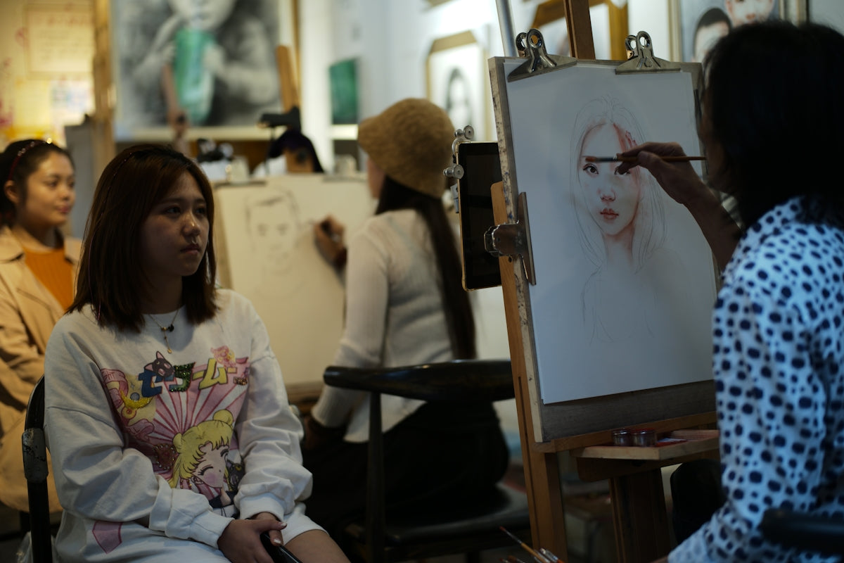 Artist sketching a portrait in a studio class
